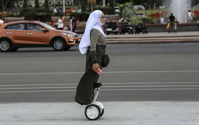 Kyrgyz woman rides a segway in downtown of Bishkek, Kyrgyzstan, 09 August 2021. The weather in the capital of Kyrgyzstan is hot with temperatures above 36 degrees. (Photo by Igor Kovalenko/EPA/EFE)