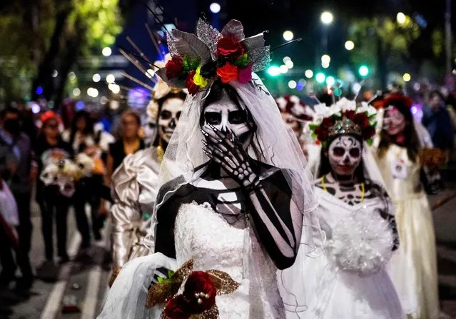 People take part in the Catrinas Parade, representing the character of La Catrina to commemorate the Day of the Dead, in Mexico City, on October 23, 2022. (Photo by Claudio Cruz/AFP Photo)