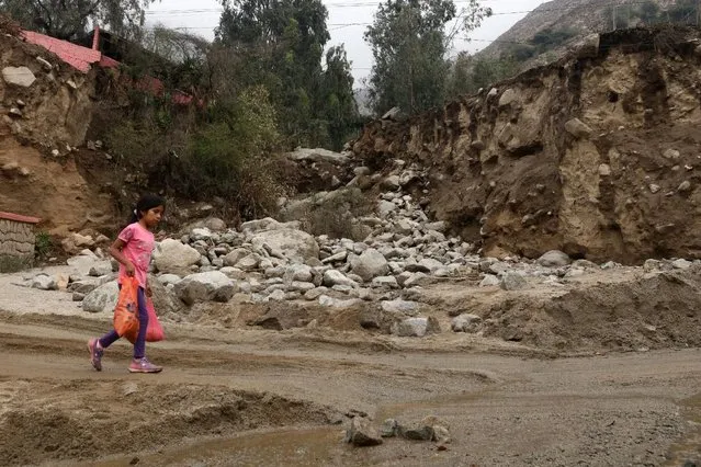 A child walks past debris  after a landslide and flood in Chosica, Peru January 16, 2017. (Photo by Guadalupe Pardo/Reuters)