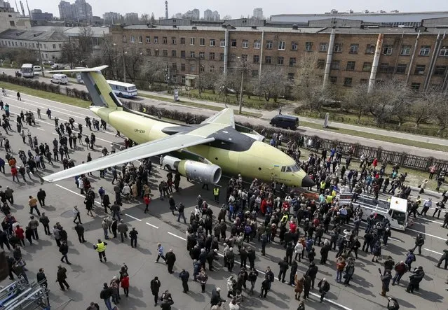 A Ukrainian plane, the An-178, is seen as workers and guests look on during a presentation ceremony in Antonov Plant in Kiev April 16, 2015. According to a press release, the An-178 transport aircraft can be used for both military and civilian purposes and can carry 18 tons of cargo with the top speed over 800 km/h. (Photo by Valentyn Ogirenko/Reuters)