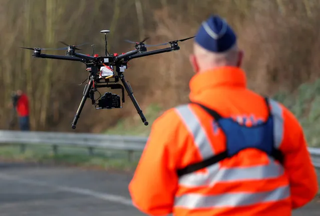 A Belgian police officer pilots a drone to showcase the use of drones deployed over traffic accidents occurring on highways, in Ranst near Antwerp, Belgium, January 18, 2017. (Photo by Francois Lenoir/Reuters)