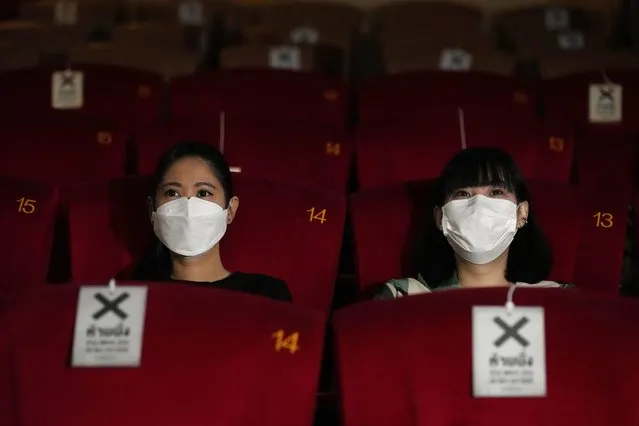 People wear face mask to help curb the spread of the coronavirus during a movie at the Paragon Cineplex movie theater in Bangkok, Thailand, Friday, October 1, 2021. Thai authorities allowed movie theater and other businesses to reopen, selectively easing restrictions against the coronavirus. (Photo by Sakchai Lalit/AP Photo)