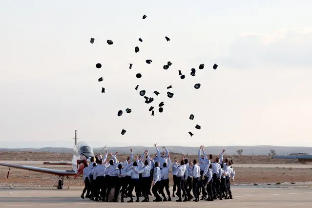 Israeli Air Force pilots throw their hats in the air as they celebrate during their graduation ceremony at the Hatzerim base in the Negev desert, near the southern city of Beer Sheva, on December 28, 2022. (Photo by Jack Guez/AFP Photo)