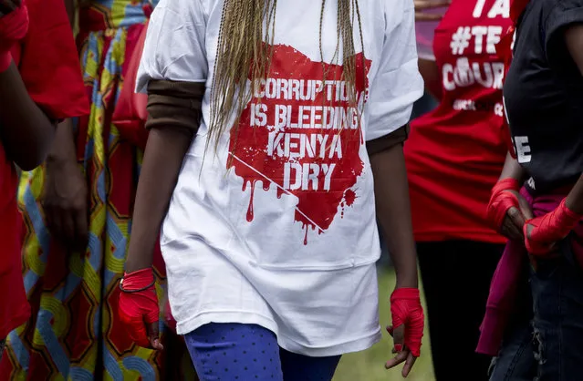 In this Tuesday, December 1, 2015 file photo, a protester wears red tape on her hands to represent boxing, during an anti-corruption demonstration in downtown Nairobi, Kenya. A survey by the Kenyan government's anti-corruption watchdog released Tuesday, March 15, 2016 shows that half of the country's citizens believe corruption has increased under President Uhuru Kenyatta's administration, with 74 percent of the population believing the level of corruption is high. (Photo by Ben Curtis/AP Photo)
