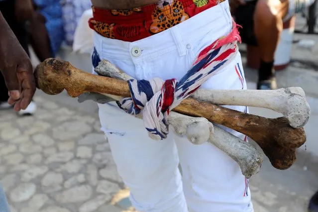A man wears a belt with human bones at a cemetery during Day of the Dead celebrations, in Port-au-Prince, Haiti on November 1, 2021. (Photo by Ralph Tedy Erol/Reuters)