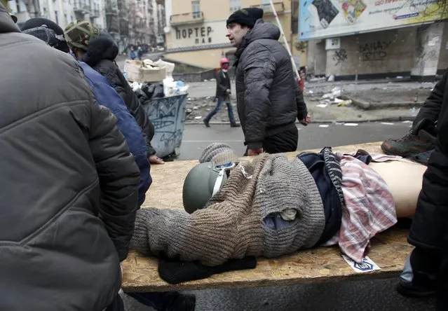 Anti-government protesters carry an injured man on a stretcher after violence erupted in the Independence Square in Kiev February 20, 2014. (Photo by David Mdzinarishvili/Reuters)