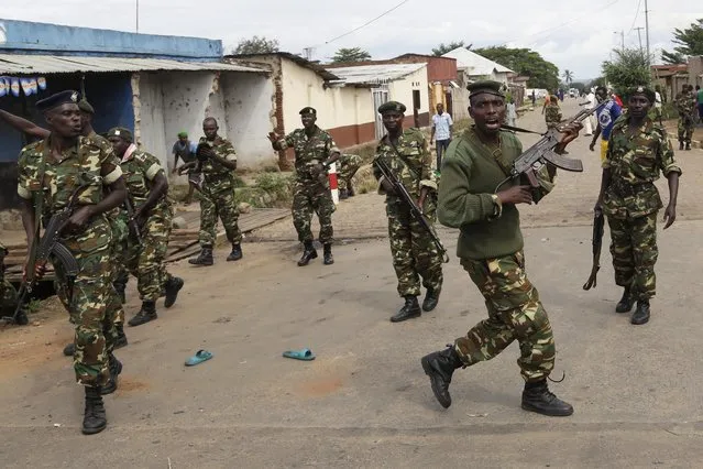 Soldiers disperse a crowd by firing into the air after demonstrators cornered Jean Claude Niyonzima a suspected member of the ruling party's Imbonerakure youth militia in a sewer in the Cibitoke district of Bujumbura, Burundi, Thursday May 7, 2015. (Photo by Jerome Delay/AP Photo)