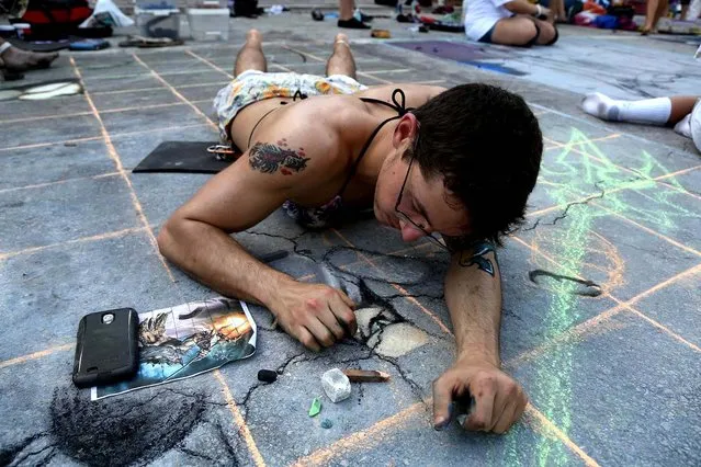 Troy Ferguson, of Lake Worth High school, chalks the pavement. (Photo by Greg Lovett/The Palm Beach Post)