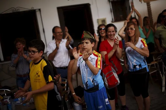 A boy wears a "chapiri" (legionnaire hat) as he applauds the participants during the XVIII 101km international competition in Setenil de las Bodegas, southern Spain, May 9, 2015. (Photo by Jon Nazca/Reuters)