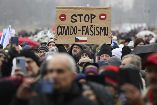 A man holds up a sign reading Stop Covid Fascism, during a protest against measures to tackle surge of COVID-19 infections, in Prague, Sunday, November 28, 2021. Thousands have rallied in the Czech capital to protest the government’s restrictive measures to tackle a record surge of coronavirus infections. The protesters included supporters of a number of fringe political parties and groups that failed to win any parliamentary seats in October’s election. (Photo by Ondrej Deml/CTK via AP Photo)