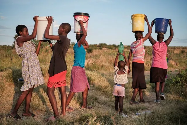 Residents of Pumula East township walk home after fetching water from a well, as temperatures soar during an El Nino-related heatwave and drought affecting a large part of the country, in Bulawayo, Zimbabwe, on March 7, 2024. (Photo by KB Mpofu/Reuters)