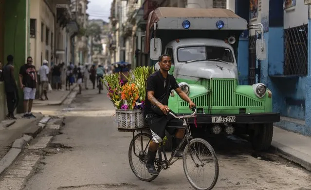A flower vendor rides past on his bicycle, in Havana, Cuba, Tuesday, January 9, 2024. (Photo by Ramon Espinosa/AP Photo)