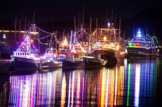Some of the approximately 50 boats in the harbour of Port de Grave, N.L. are lit up for Christmas on Thursday, December 16, 2021. The annual boat lighting has been ongoing for more than 20 years. (Photo by Canadian Press/Rex Features/Shutterstock)