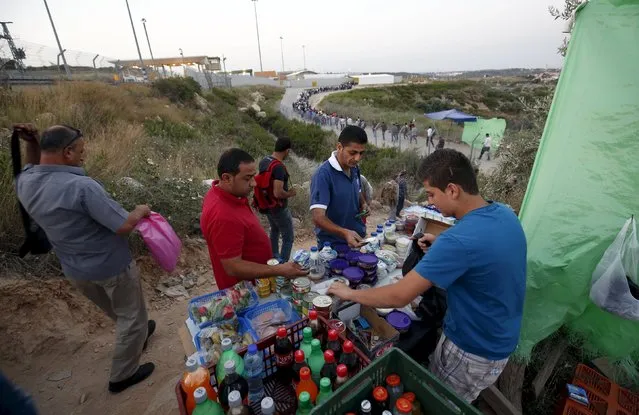 Palestinian labourers buy food supplies before they cross into Israel through Hashmonaim checkpoint near the West Bank village of Nilin, west of Ramallah May 25, 2015. (Photo by Mohamad Torokman/Reuters)