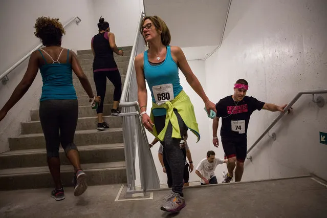 People run in the “Runyon Up” a stair race in which participants run up 72 floors of stairs inside the Four World Trade Center building on April 3, 2014 in New York City. The race attracted hundreds of participants, with the winner finishing in under 10 minutes. The run raised money and awareness for cancer research.  (Photo by Andrew Burton/Getty Images)