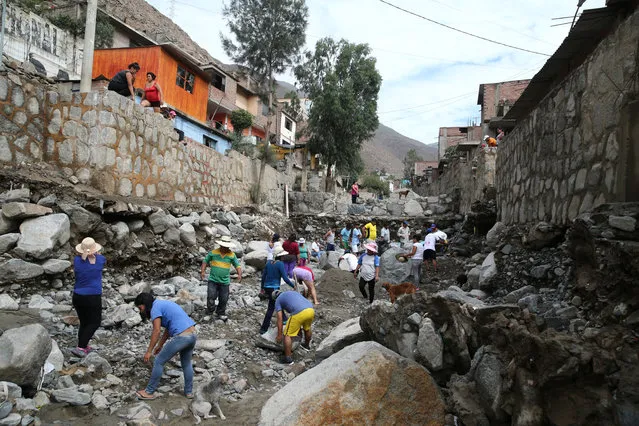 People remove debris after a landslide and flood in Chosica, Peru on March 16, 2017. (Photo by Guadalupe Pardo/Reuters)