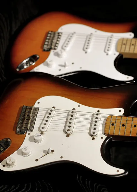 An original 1954 Fender Stratocaster, foreground, is shown next to a 2014 model at a studio in Scottsdale, Ariz. on Friday, January 10, 2014. The Stratocaster has a unique voice that differs from other electric guitars due to its 3 pickups and has been described as “glassy”, “bright” or “clean”. (Photo by Matt York/AP Photo)