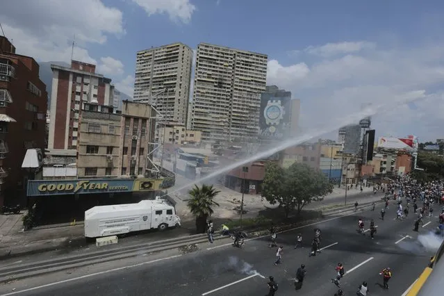 Riot police use water cannons to disperse people during a protest in Caracas, Venezuela, Thursday, April 6, 2017. (Photo by Fernando Llano/AP Photo)