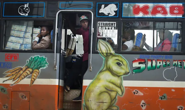 The conductor of a public minibus, known locally as a matatu, looks out as the bus passes opposition supporters staging a protest in Nairobi, Kenya Monday, May 9, 2016. (Photo by Ben Curtis/AP Photo)