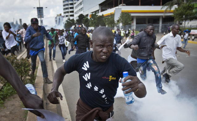 Opposition supporters flee from tear gas grenades fired by riot police, during a protest in downtown Nairobi, Kenya Monday, May 16, 2016. (Photo by Ben Curtis/AP Photo)