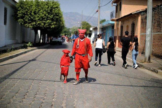 Father and son dressed as demons participate in a ceremony known as Los Talciguines, as part of religious activities to mark the start of the Holy Week in Texistepeque, El Salvador on April 3, 2023. (Photo by Jose Cabezas/Reuters)