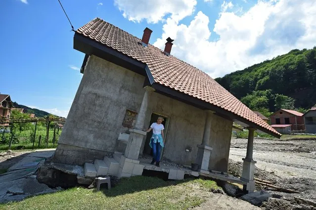 Flood victim Pavlovic Oksana stands on the front porch of her house, damaged by flooding and landslide, in Krupanj, some 130 kilometres south west of Belgrade, on May 20, 2014, after the western Serbian town was hit with floods and landslides, cutting it off for four days. Serbia declared three days of national mourning on May 20 as the death toll from the worst flood to hit the Balkans in living memory rose and health officials warned of a possible epidemic. (Photo by Andrej Isakovic/AFP Photo)