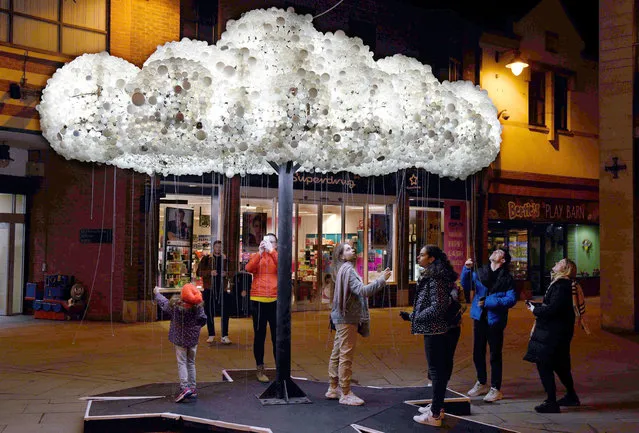 Visitors admire the artwork “Cloud”, formed from 6,000 incandescent light bulbs, during a dress rehearsal for “Lumiere Durham” light festival in Durham, northeast England on November 13, 2019. (Photo by Oli Scarff/AFP Photo)