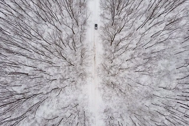 An aerial photo taken with a drone shows a car driving through a snow covered landscape near Debrecen, Hungary, 02 February 2022. (Photo by Zsolt Czegledi/EPA/EFE)