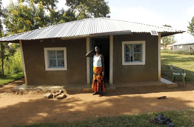 Peris Aoko, a 37-year-old housewife, poses for a photograph outside her home in Kogelo, west of Kenya's capital Nairobi, July 15, 2015. Aoko said, “We expect the U.S. president to come home as a son of this land. Kogelo is the 53rd State of the United States of America”. (Photo by Thomas Mukoya/Reuters)