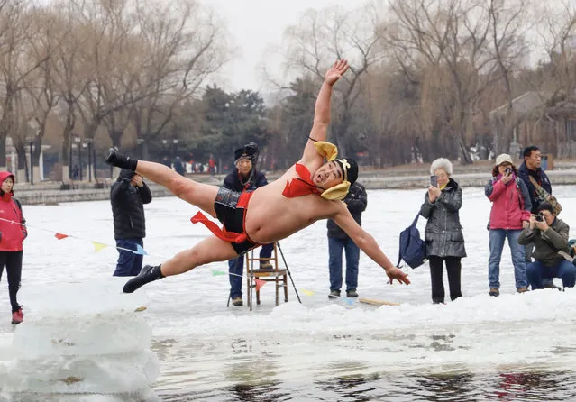 A man wearing a costume dives into a partly frozen lake in Shenyang, in China's northeastern Liaoning province on February 19, 2019. (Photo by AFP Photo/China Stringer Network)