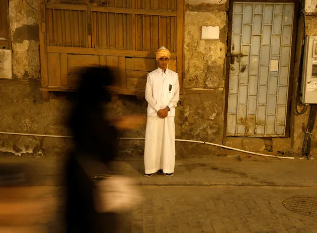 A woman walks past a boy wearing a traditional costume during the holy fasting month of Ramadan at Jeddah's historical area Al-Balad, Saudi Arabia June 9, 2016. (Photo by Faisal Al Nasser/Reuters)