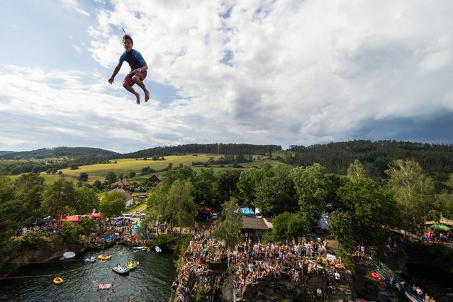  competitor jumps into the water during a cliff diving competition near the Central Bohemian village of Hrimezdice, Czech Republic, on August 3, 2024. (Photo by Eva Korinkova/Reuters)