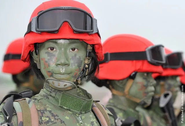 A group of Taiwanese women paratroops pose for photos after a drill held at Taiwan's northern Hsinchu airbase. Taiwan tested its ability to defend one of its largest air bases against Chinese invasion