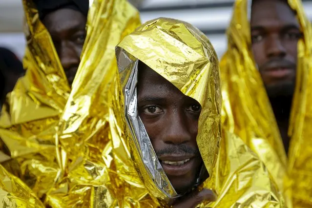 A migrant waits to disembark from a Coast Guard ship in the Sicilian harbour of Messina, Italy August 4, 2015. Around 300 migrants were taken to safety in the Sicilian port of Messina on Tuesday after being rescued at sea near Libya. The migrants from Sub-Saharan Africa had been rescued on Monday after travelling on two dinghies sailing towards Europe. (Photo by Antonio Parrinello/Reuters)