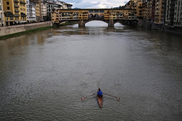 A man rows his canoe on the Arno river in front of Ponte Vecchio (Old Bridge) in Florence, Italy on December 11, 2021. (Photo by Nacho Doce/Reuters)