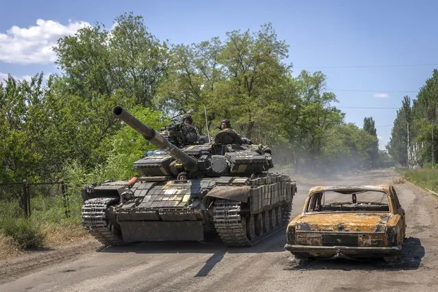 Ukrainian servicemen drive a tank near the frontline in Donetsk region, eastern Ukraine, Monday, June 6, 2022. (Photo by Bernat Armangue/AP Photo)