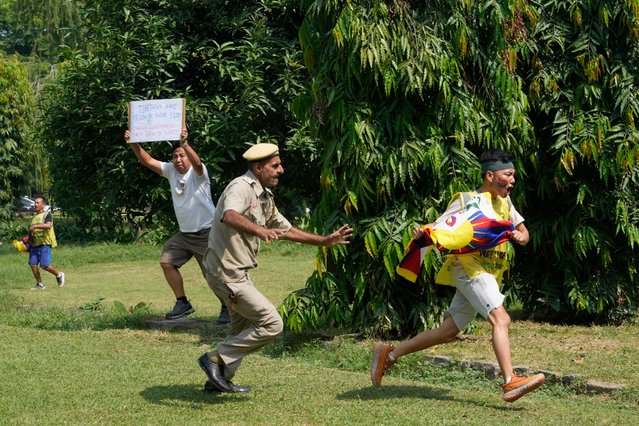 An Indian policeman runs after an exile Tibetan to detain him as others shout slogans against the human rights situation in Tibet during a protest to coincide China marking its 75th year of Communist Party rule, outside Chinese embassy, in New Delhi, India, Tuesday, October 1, 2024. (Photo by Manish Swarup/AP Photo)