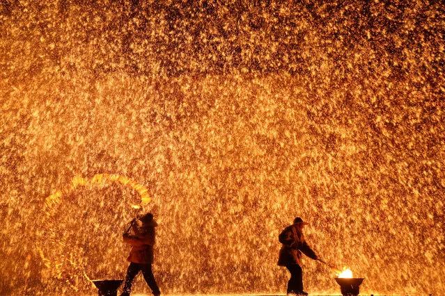 Performers throw molten iron against a wall to create sparks during a traditional performance ahead of the Dragon Boat festival in Zhangjiakou, Hebei province, China May 29, 2017. (Photo by Reuters/China Daily)