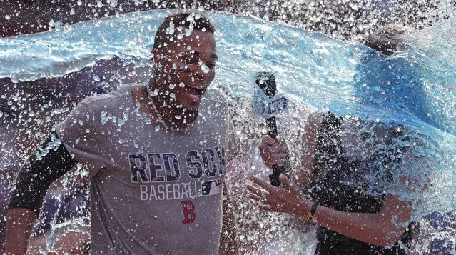 Boston Red Sox's Xander Bogaerts, left, and TV reporter Guerin Austin are doused following Bogaert's' walkoff RBI-single during the 10th inning of a baseball game against the Chicago White Sox at Fenway Park, Thursday, June 23, 2016, in Boston. (Photo by Charles Krupa/AP Photo)