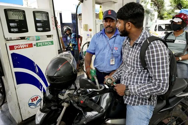 A motorcyclists watches as an employee of a fuel stationin fills petrol, in Mumbai, India, Saturday, June 11, 2022. India and other Asian nations are becoming an increasingly vital source of oil revenues for Moscow as the U.S. and other Western countries cut their energy imports from Russia in line with sanctions over its war on Ukraine. (Photo by Rajanish Kakade/AP Photo)