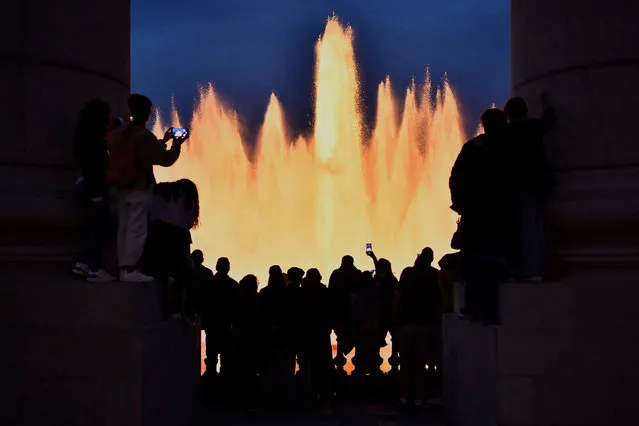People gather to watch the Magic Fountain's lights and music show on April 30, 2022 in Barcelona. (Photo by Pau Barrena/AFP Photo)