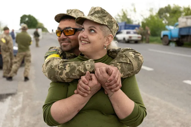 Ukrainian soldiers Yashka and Olga embrace while the convoy makes a stop on its way to the eastern front, near Oleksandriya, Ukraine on May 15, 2022. (Photo by Jorge Silva/Reuters)