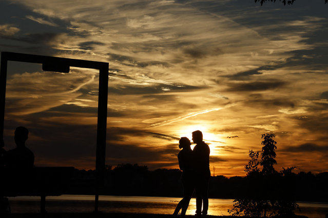 People enjoy the sunset near Lake Champlain on September 28, 2024, in Venise-en-Québec, Canada. (Photo by Ludovic Marin/AFP Photo)