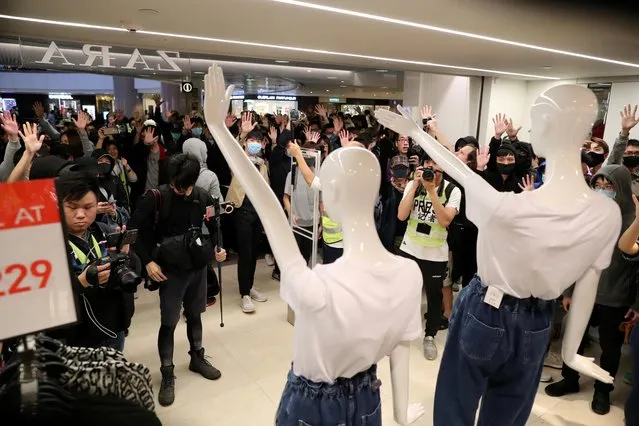 Hong Kong protesters gesture toward mannequins they rearranged to make a protest gesture during a march in Harbour City shopping mall in Hong Kong, China, December 21, 2019. (Photo by Lucy Nicholson/Reuters)