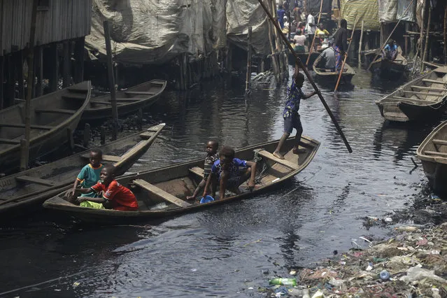 People travel by canoe in the floating slum of Makoko in Lagos, Nigeria, Saturday March 21, 2020. Lockdowns have begun in Africa as coronavirus cases rise above 1,000, while Nigeria on Saturday announced it is closing airports to all incoming international flights for one month in the continent's most populous country. Concerns are mounting for the welfare of Nigeria's most vulnerable community on stilts over spread of Covid-19 with little or no chances for social distancing as confirmed positive cases of the disease is on the rise. (Photo by Sunday Alamba/AP Photo)