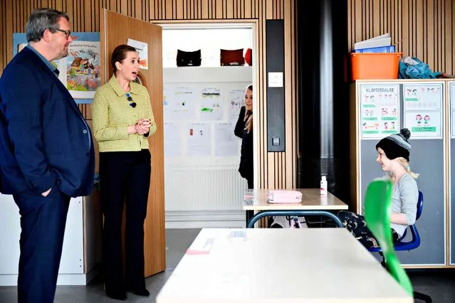 Danish Prime Minister Mette Frederiksen (2nd L) speaks with a pupil as she participates in the reopening of Lykkebo School in Valby in Copenhagen on April 15, 2020, after the lockdown to limit the spread of the new coronavirus. Denmark began reopening schools after a month-long closure over the novel coronavirus, becoming the first country in Europe to do so. Nurseries, kindergartens and primary schools were reopening, according to an AFP correspondent, after they were closed on March 12, 2020 in an effort to curb the COVID-19 epidemic. (Photo by Philip Davali/Ritzau Scanpix/AFP Photo)