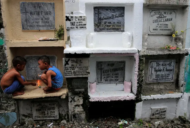 Children play in front of the apartment tombs during the observance of All Saints' Day at Navotas public cemetery in Metro Manila, Philippines, November 1, 2017. (Photo by Romeo Ranoco/Reuters)