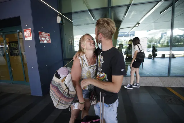 Andrea Monti hugs his girlfriend Katherina Scherf who just arrived from Duesseldorf, Germany at Rome's Fiumicino airport, Wednesday, June 3, 2020. Rome’s Fiumicino airport sprang back to life on Wednesday as Italy opened regional and international borders in the final phase of easing its long coronavirus lockdown, allowing families and loved ones separated by the global pandemic to finally reunite. (Photo by Alessandra Tarantino/AP Photo)