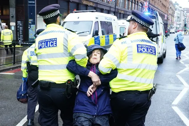 Police officers deal with activists from Just Stop Oil during their protest outside Harrods department store in Knightbridge, London on Thursday, October 20, 2022. (Photo by Ian West/PA Images via Getty Images)