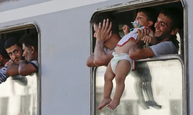 A migrant carries a child in a train at the station in Beli Manastir, Croatia September 18, 2015. (Photo by Laszlo Balogh/Reuters)